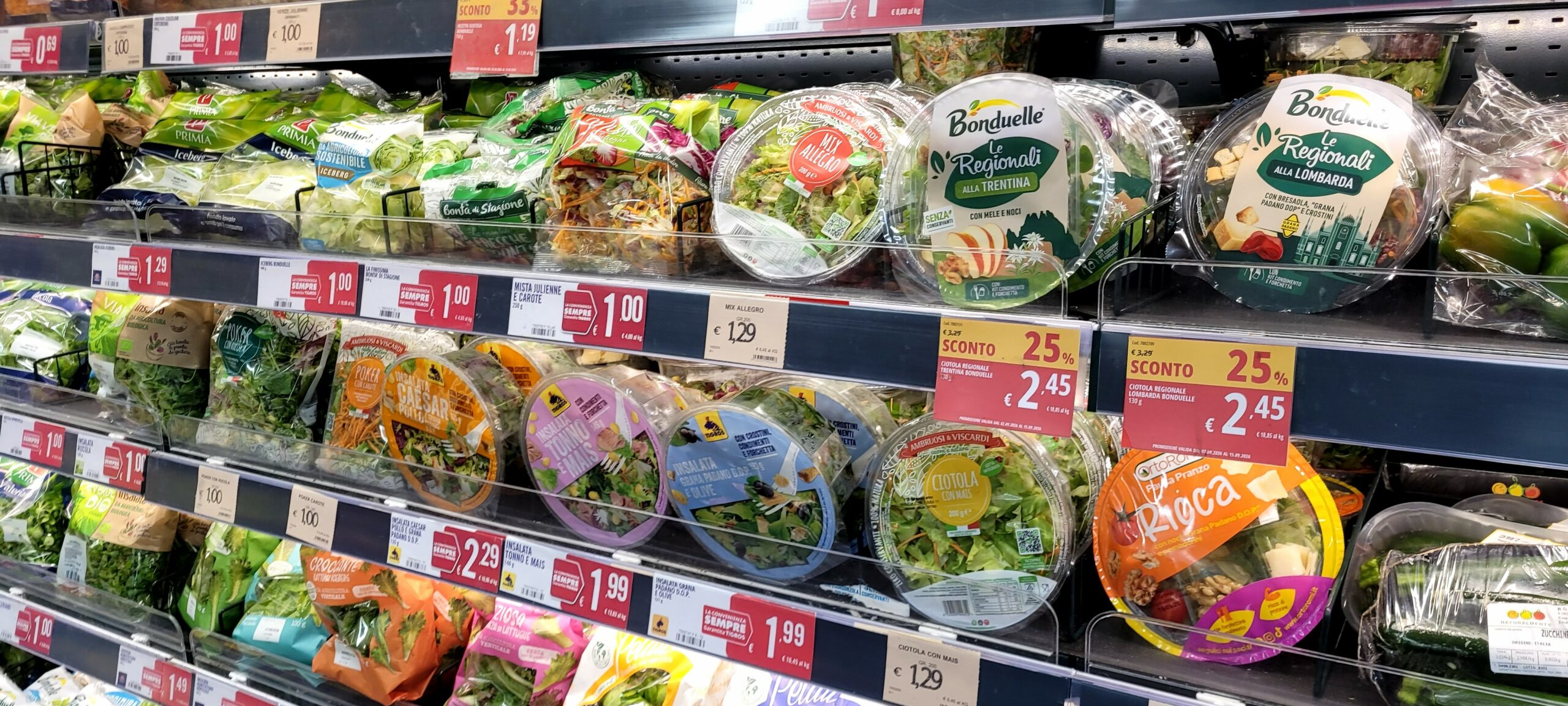Scaffale del supermercato con confezioni di insalate pronte al consumo di quarta gamma.